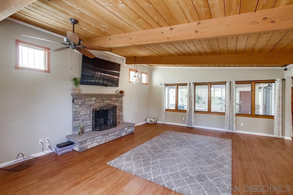 Living room with stone fireplace and wood-beam ceiling